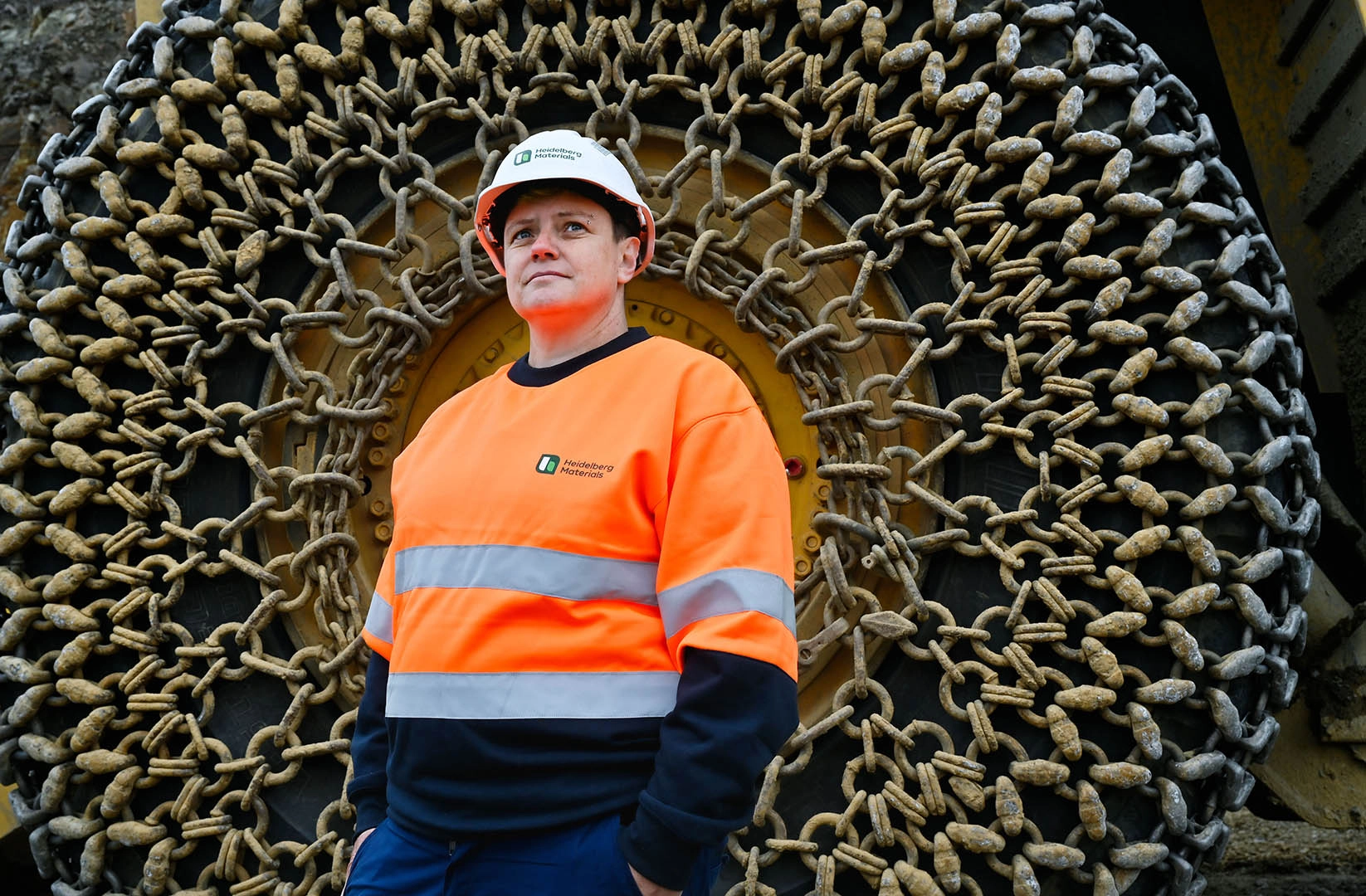 Staff member in PPE standing in front of a huge wheel of a truck