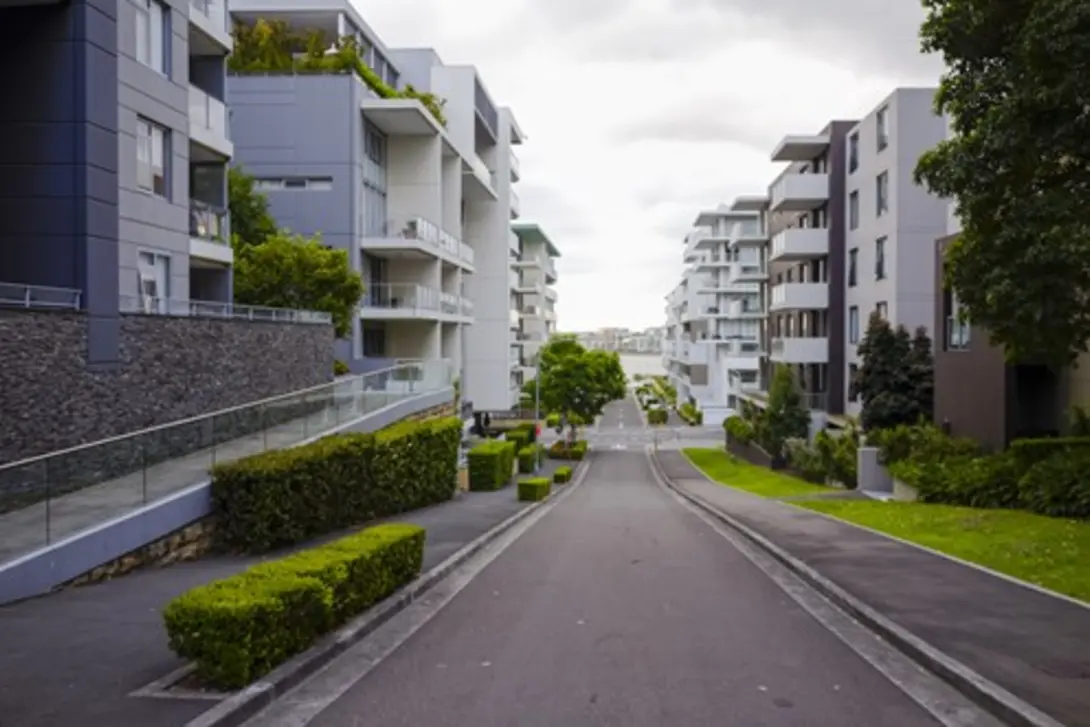 Modern residential street with newly constructed road and surrounding apartments, showcasing smooth and durable concrete suitable for fast-setting urban infrastructure applications.