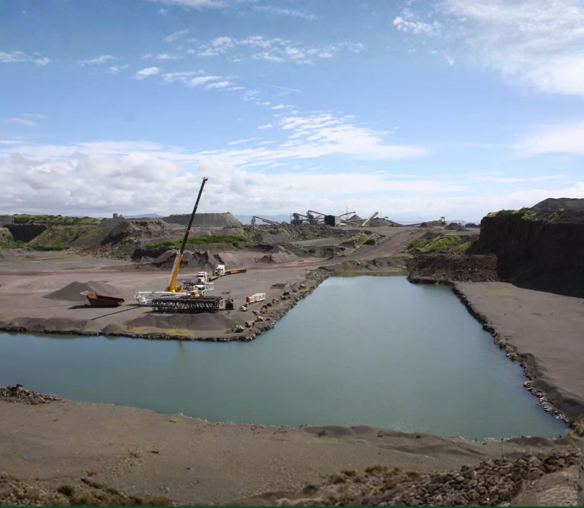 Wide view of Heidelberg Materials Australia’s Bass Point Quarry featuring quarry operations, processing equipment, stockpiles and onsite water management areas under a bright sky.