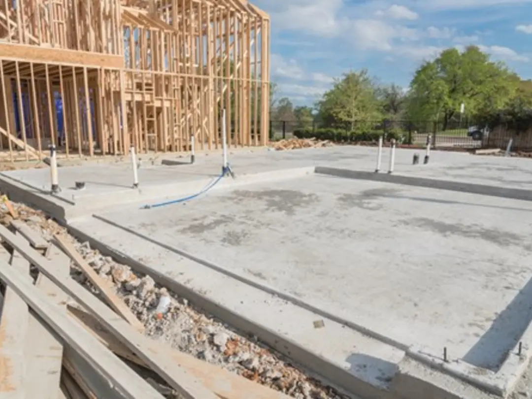 Concrete slab foundation (Slabcrete) poured on a construction site with timber framing structure in progress