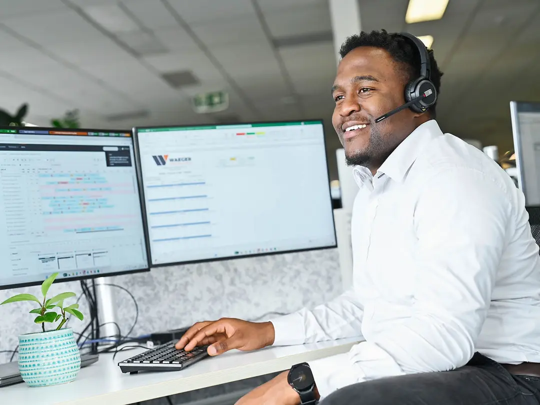 Team member at Heidelberg Materials Customer Service Centre using dual monitors and headset to manage customer orders and scheduling
